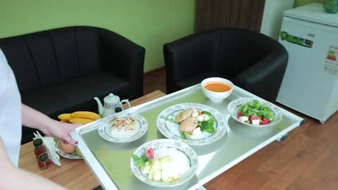 A nurse sets up a table for a patient's lunch in a medical ward Stock Footage 245415368