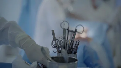 Nurse takes sterilized instruments for surgery on the heart by surgeons. Stock-Footage 104919915
