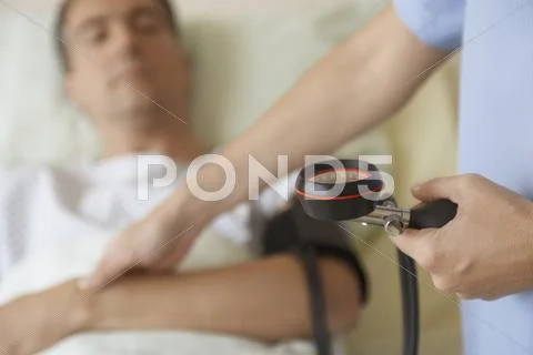 Nurse Taking Blood Pressure And Pulse Of Patient Stock Photos