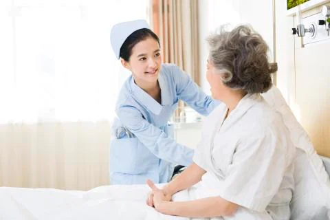 Nurse taking care of senior woman in hospital Stock Photos
