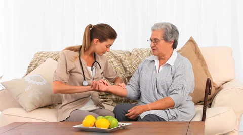Nurse taking the pulse of her patient Stock Footage