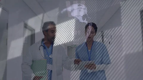 Nurse tapping tablet, doctor walking in corridor reviewing patient data Stock Footage 312499889