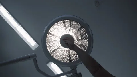 Nurse turning on shadowless surgical LED light, lamp slowly lights up Stock-Footage 201729208