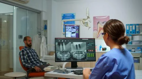 Nurse typing on computer with digital x-ray Stock-Fotos