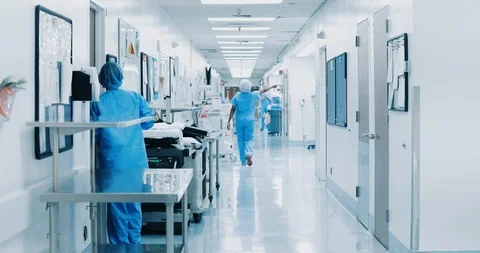 Nurse walking down clean modern hospital corridor in scrubs Stock Footage 127115223