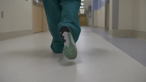 Nurse walking down hallway 스톡 동영상 145076094