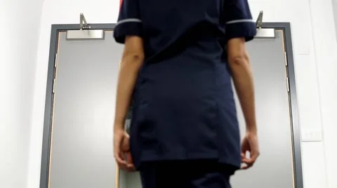 Nurse walks through hospital doors toward a and e low angle 스톡 동영상 59087310
