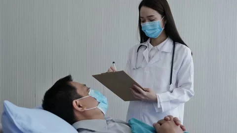 A nurse whos interview and recorded the symptoms of the male patient. Stock Footage 137906089