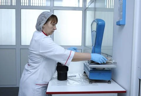 Nurse working at the table with scale holding containers with blood for wei.. Stock Photos