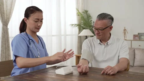Nurse wraps old man's arm testing blood pressure Stock Footage 204789890