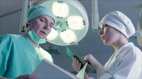 Nurse writing down directions of a surgeon in the tablet Stock Footage 75245673