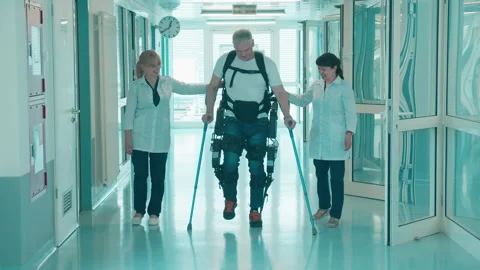 Nurses are helping a handicapped man to walk in the exoskeleton Stock Footage 158153236