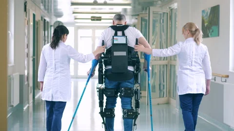 Nurses are helping a handicapped patient to walk in the exosuit Video stock 158157743