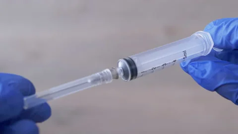 Nurses Hands Holding an Injection Syringe in Latex Nitrile Blue Gloves. 4K Stock Footage 151074824