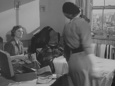 Nurses packing clothes and talking together in room, looking out of window, 1951 Stock Footage 134029273