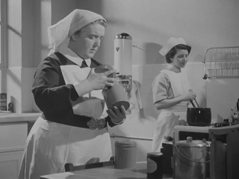 Nurses preparing tea in kitchen, young nurse ending her night shift, UK 1951 Stock Footage 134030847