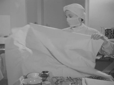 Nurses preparing tools and place for upcoming surgery with doctor, UK 1951 Stock Footage 134030401