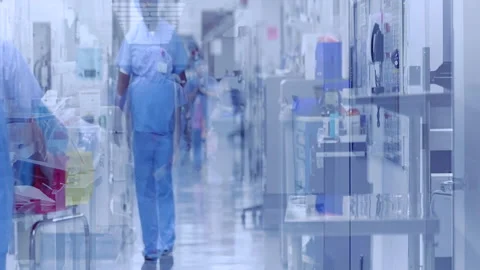 Nurses Surgeons and doctors walk down hospital corridor in scubs waving Stock Footage 146727994