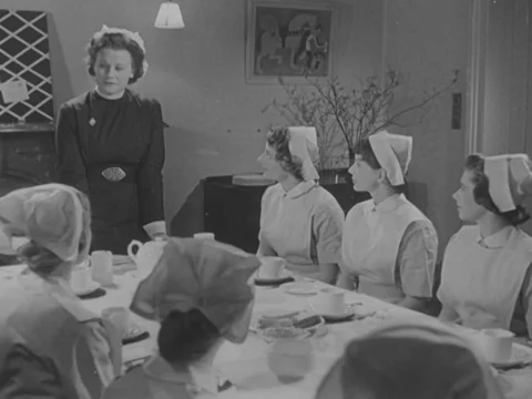 Nurses in training listening to teacher at table before breakfast, UK 1951 Stock Footage 134029170