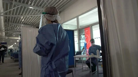 Nurses wait to perform COVID-19 tests to tourists at the Athens Airport Stock Footage 142873269
