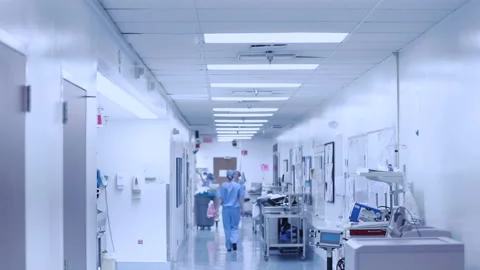 NURSES WALKING DOWN HOSPITAL CORRIDOR IN BLUE SCRUBS Stock Footage 146722315
