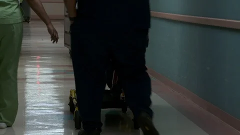 Nurses wheel stretcher down hallway, interior hospital. Vídeo Stock 111330258