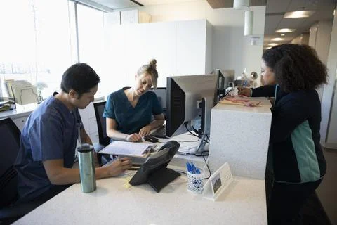 Nurses working at nurses station in clinic Stock Photos