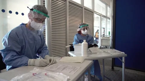 Nurses writing down after the covid-19 tests at the Athens airport 스톡 동영상 142864250