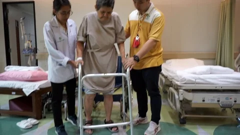 Nursing assistant, helping elderly patients, female walking practice Stock Footage 124939624