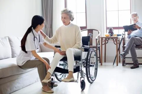Nursing assistant taking care of senior woman in wheel chair 스톡 사진