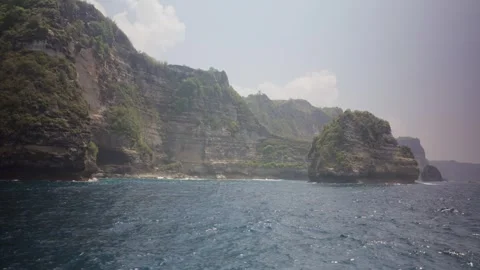 Nusa penida rugged cliffs rising from the ocean water Vídeo Stock 341515687