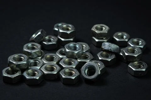 Nut bolts on a black background. threaded fastener.  Stock Photos