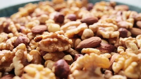 Nut mix of walnuts, hazelnuts and almonds bowl video 4k Stock Footage 231633900