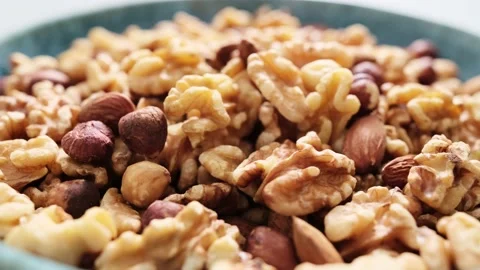 Nut mix of walnuts, hazelnuts and almonds bowl video 4k Stock Footage 232215283