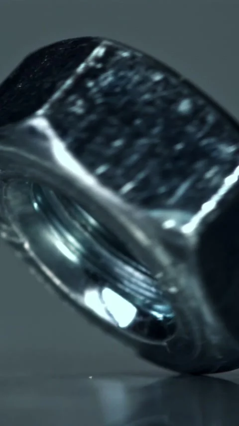 The nut is spinning on a metal table. Filmed on a high-speed camera at 1000 fps Stock Footage 335371871