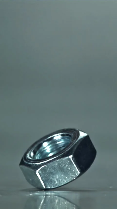 The nut is spinning on a metal table. Filmed on a high-speed camera at 1000 fps Stock Footage 335375684