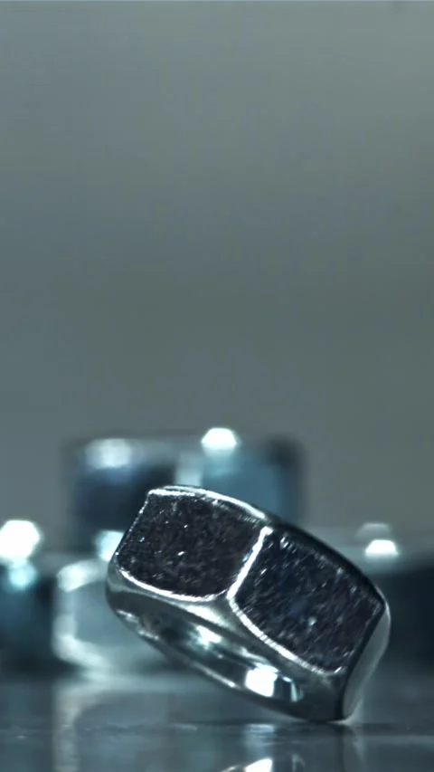 The nut is spinning on a metal table. Filmed on a high-speed camera at 1000 fps Stock Footage 335384607