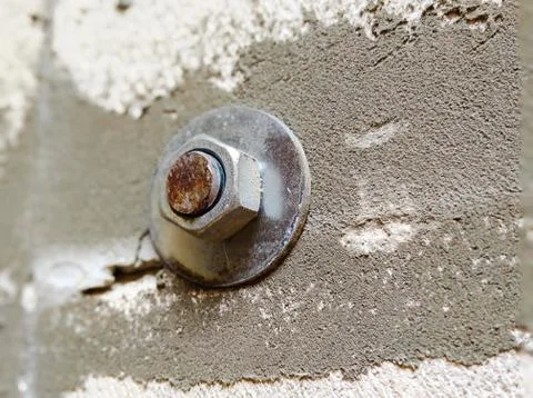  Nut tighten in cement wall background Stock Photos