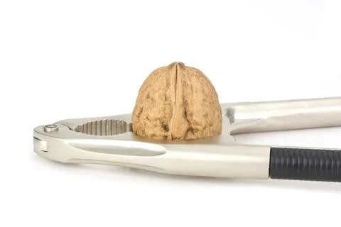 Nutcracker and a walnut isolated on white background Stock Photos