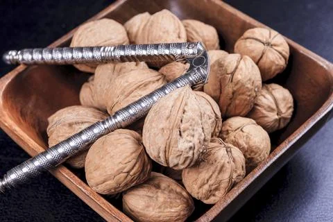 Nutcracker and walnuts in a bowl. Stock Photos