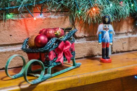 Nutcracker doll and a small sleigh decorating a fireplace Stock Photos