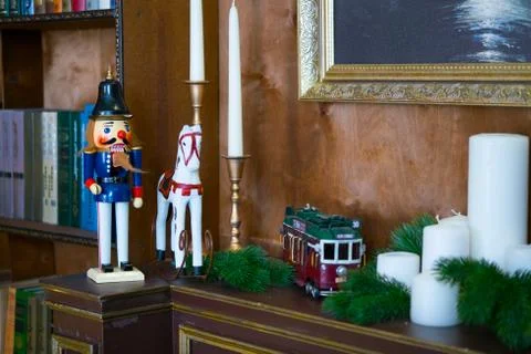 Nutcracker doll on the mantelpiece in the library. Book is the background Stock Photos