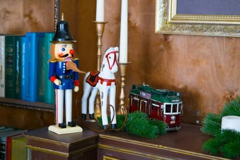 Nutcracker doll on the table with candles in the library. Book is the background Stock Photos