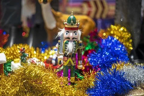 Nutcracker figurine on Afon confit and Christmas paper garlands.Stylish gif.. Stock Photos