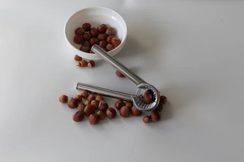 The nutcracker lies on the nuts, next to the plate with hazelnuts Foto stock