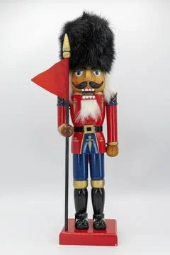 Nutcracker Soldier Figure With Flag Standing on a Plain Background Stock Photos