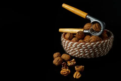 Nutcracker with some walnut at black background Stock Photos