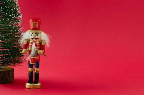 A nutcracker is standing in front of a Christmas tree Stock Photos