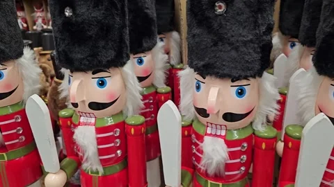 Nutcracker toys are arranged on a store shelf alongside Christmas tree ornaments Stock Footage 303606276