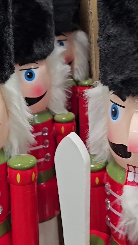 Nutcracker toys are arranged on a store shelf alongside Christmas tree ornaments Stock Footage 305990799